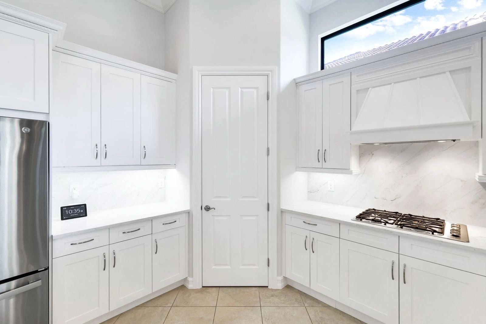 Bright white kitchen with clean cabinetry and modern appliances.