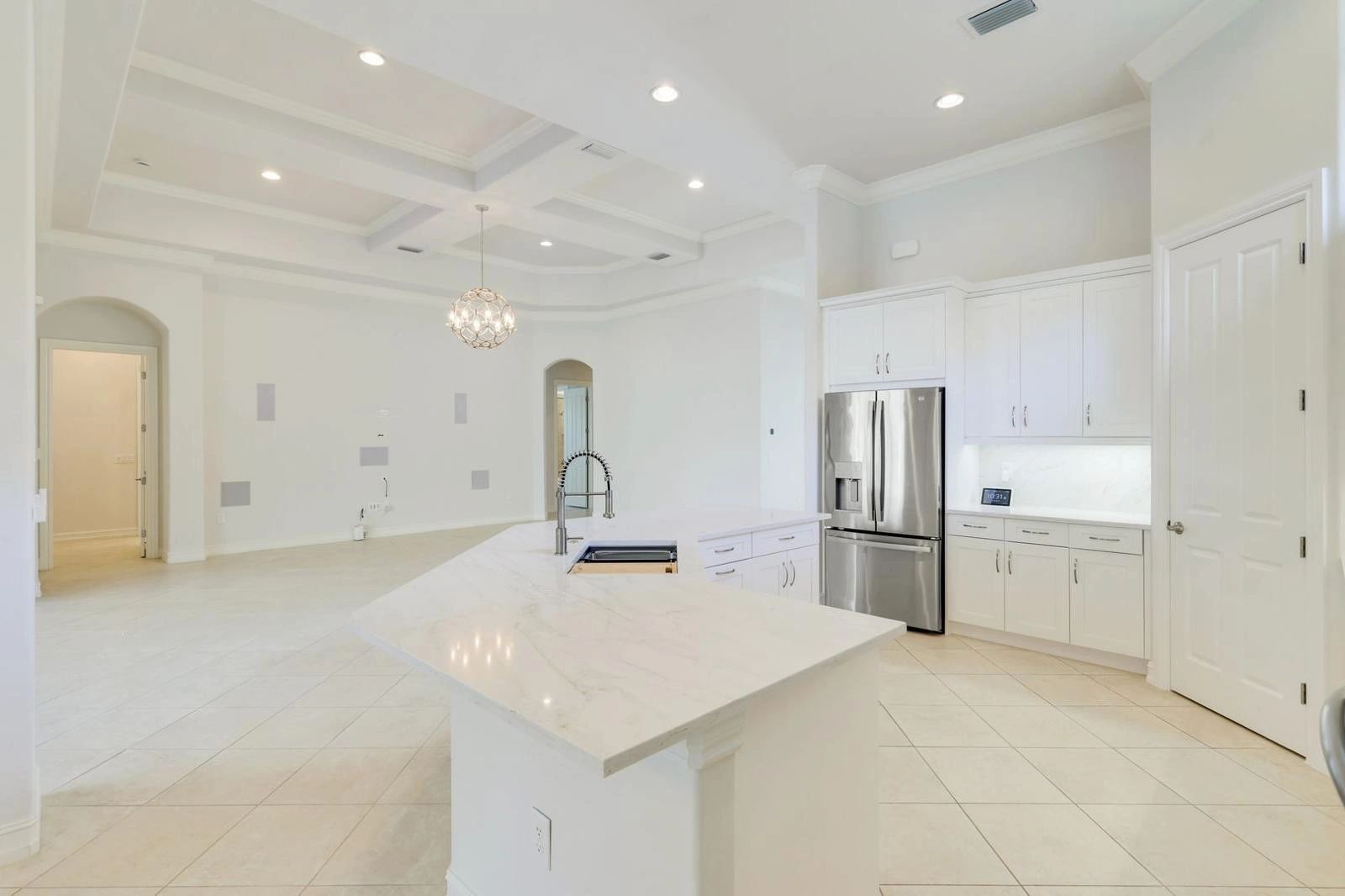 Bright modern kitchen with white cabinetry and marble island.