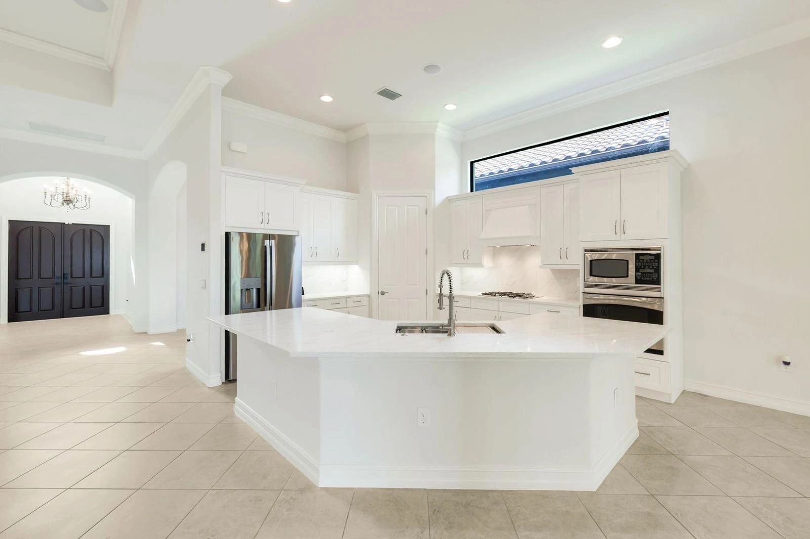 Bright modern kitchen with white cabinetry and large island.