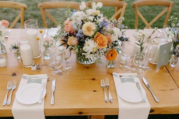 Colorful summer centerpiece in colors of orange, light blue, pink, peach and white flowers. 