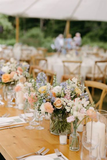 Garden style flowers arrangment on a long farmhouse table at a wedding. 