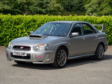 Silver Subaru Impreza WRX with sporty design and hood scoop.