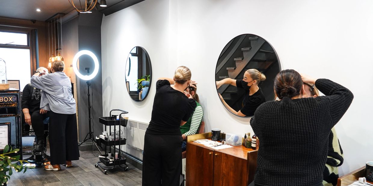 People getting makeup done in a modern salon.