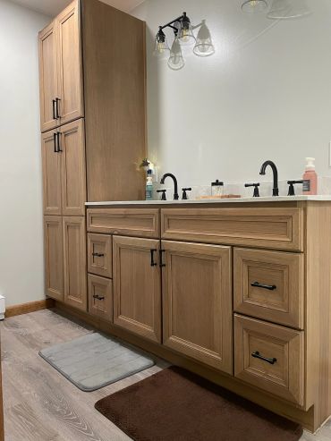 Modern bathroom vanity with wooden cabinets and dual sinks.