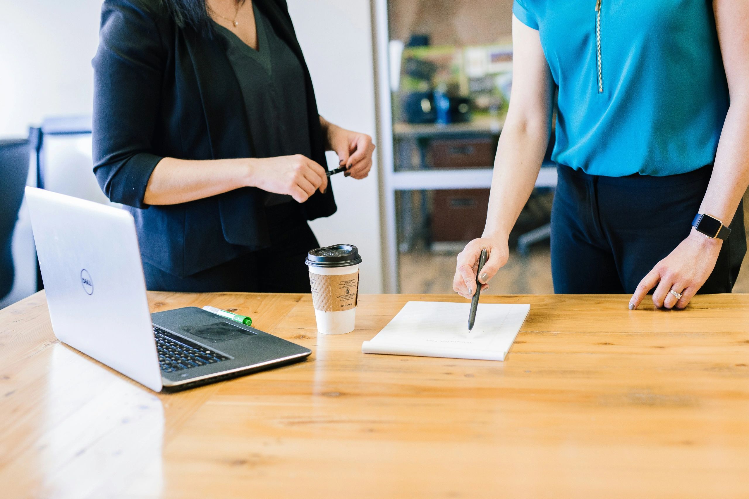 Two women working on a project in an office setting.