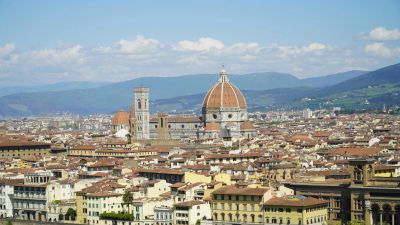 Cityscape with a large domed cathedral and surrounding buildings.