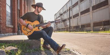 Ty Baynton playing his custom, spruce top hollow-body Cithara guitar.