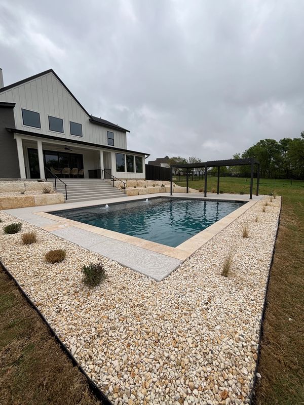 Field technician pressure washing a fence.
