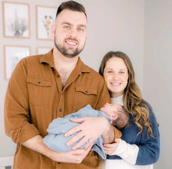 Couple proudly holding their newborn baby.