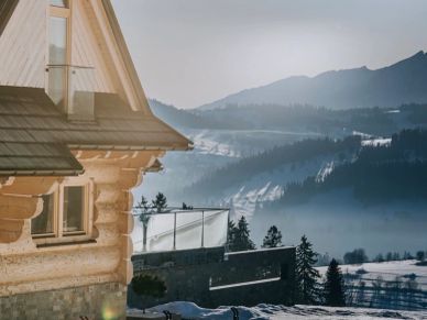 Snowy mountain landscape seen from a wooden house.