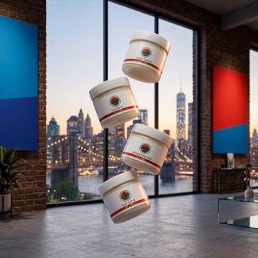 Four skincare jars floating in a modern loft with a cityscape backdrop.