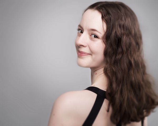 Young woman smiling over her shoulder.