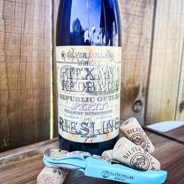 Bottle of Silver Dollar Winery Texan Redback Riesling with corks and a blue wine opener.
