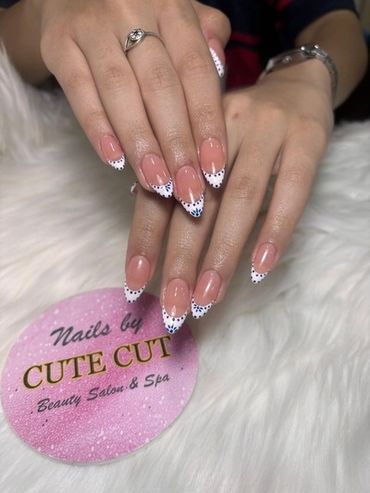 Elegant almond-shaped French tip manicure featuring white tips decorated with delicate blue polka do