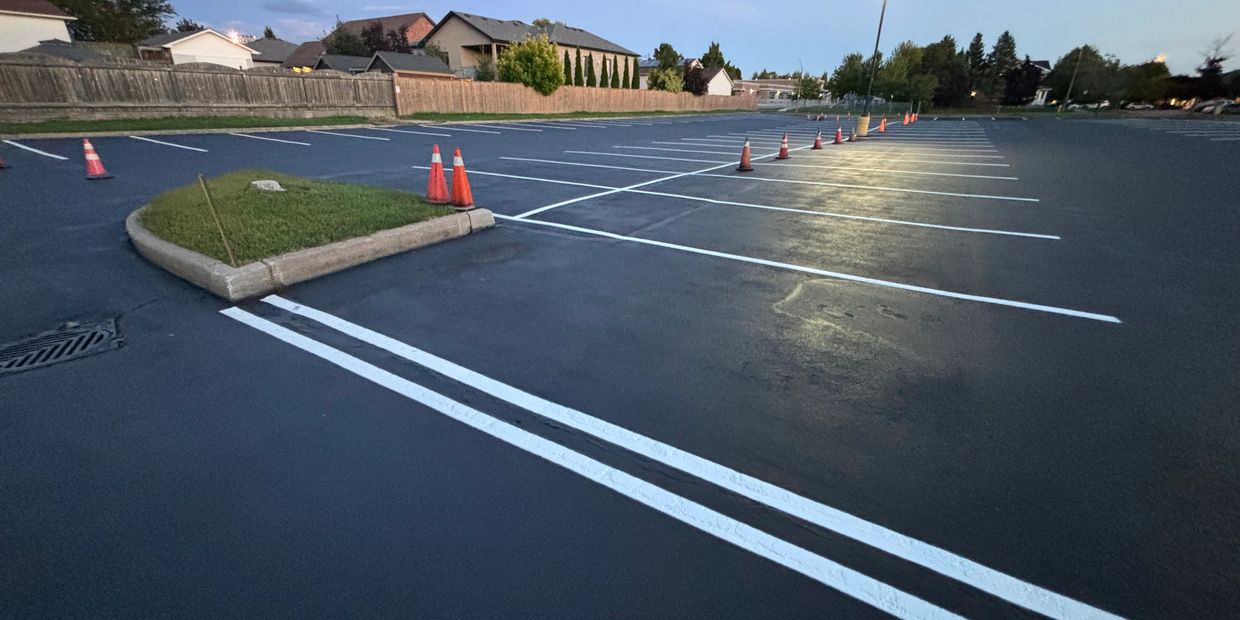 Empty parking lot with fresh paint and traffic cones at dusk.