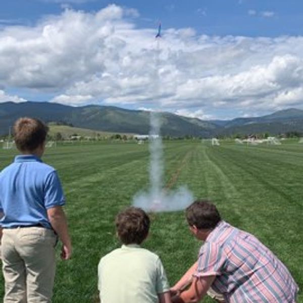 male student launching rocket he made