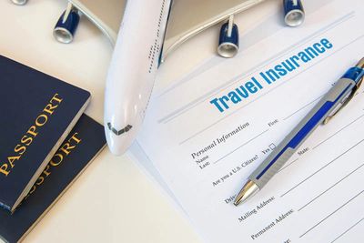 Travel insurance form with passports and a model airplane.