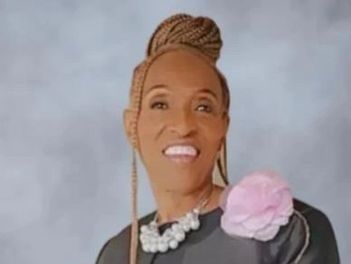 A person with braided hair smiling.