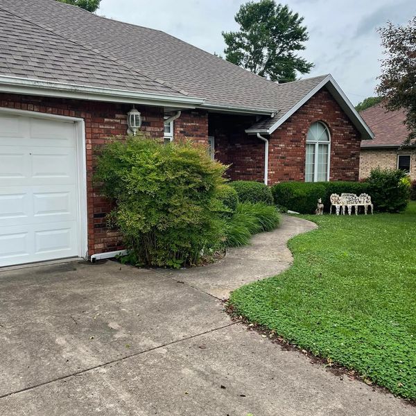 Dirty driveway and sidewalk with heavy algae buildup before surface cleaning in Springfield MO