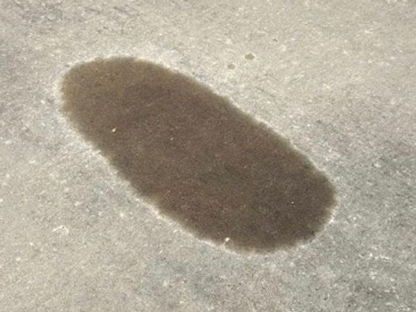 Oil stain on concrete driveway in Springfield MO before pressure washing treatment