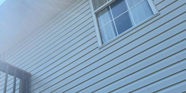 Clean vinyl siding on a house in Republic, Missouri, soft washing is safer than pressure on surfaces