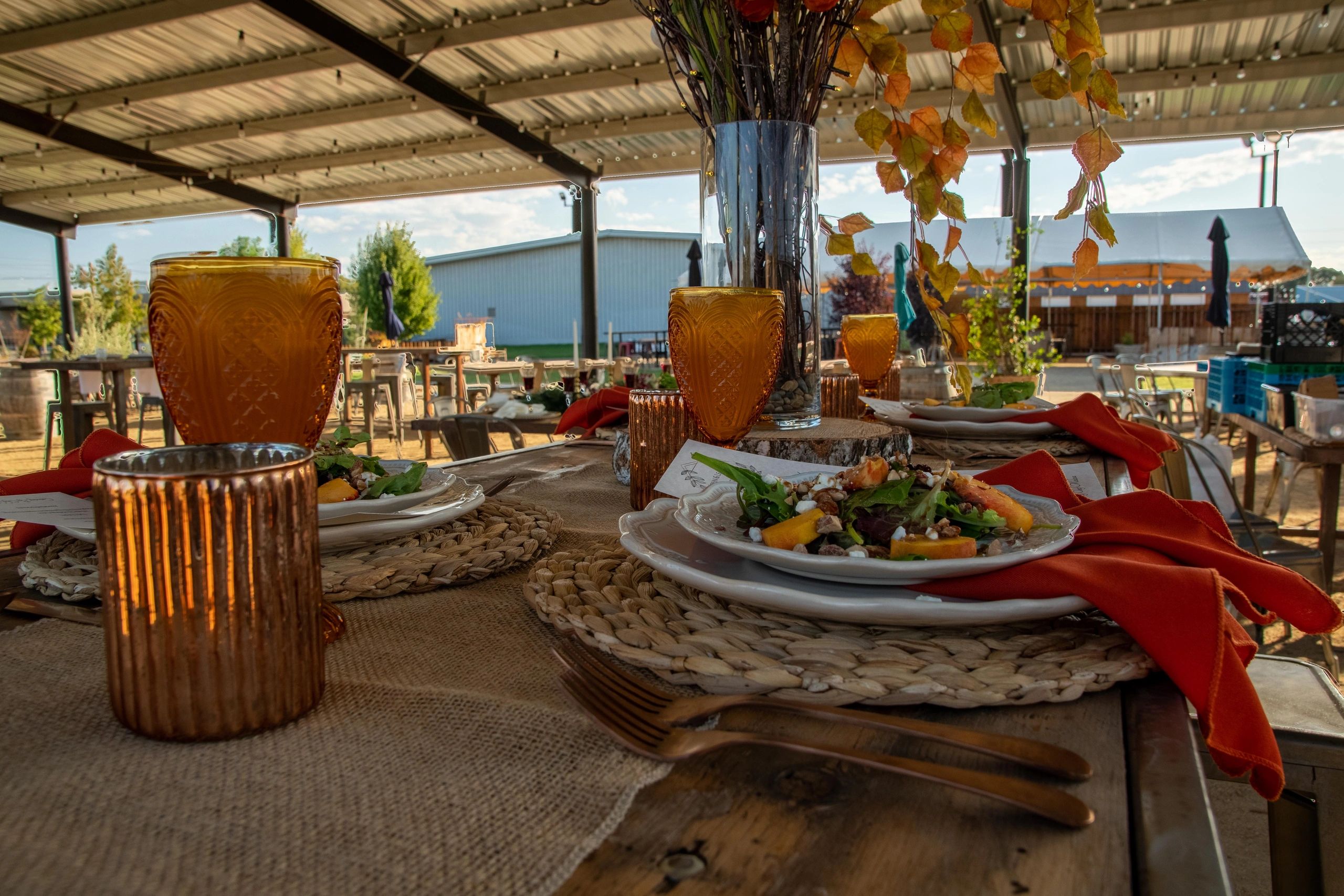 Table set for a wedding reception under the covered pavilion at The Tarmac Event Venue in Atwater, C