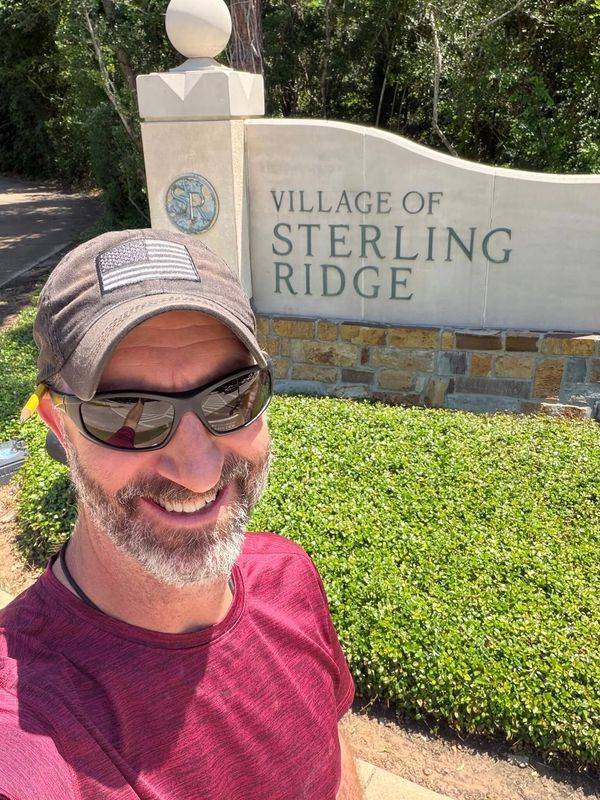 Adam Taylor the Handyman standing in front of the entrance sign to Sterling Ridge, The Woodlands, TX