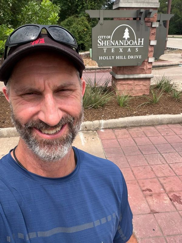 Adam Taylor the Handyman standing in front of the Shenandoah, TX entrance sign.