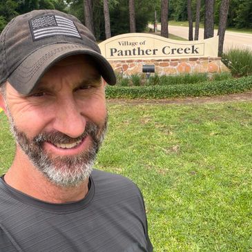 Adam Taylor standing in front of the entrance sign to Panther Creek, The Woodlands, TX