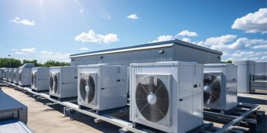 Multiple large HVAC units installed on a rooftop under a clear sky.