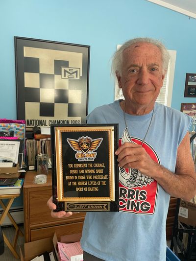 Man holding a racing award plaque.