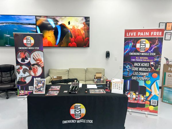 Emergency Muscle Stick promotional booth with banners and product displays.