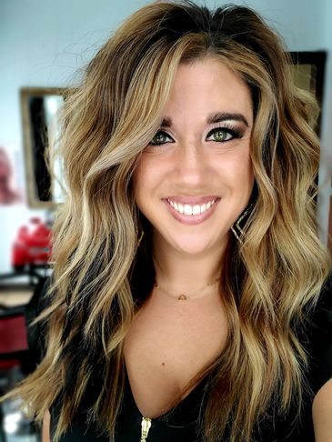 Smiling woman with long wavy blonde and black hair.