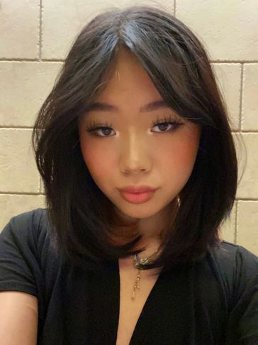 A young woman with shoulder-length black hair and subtle makeup.
