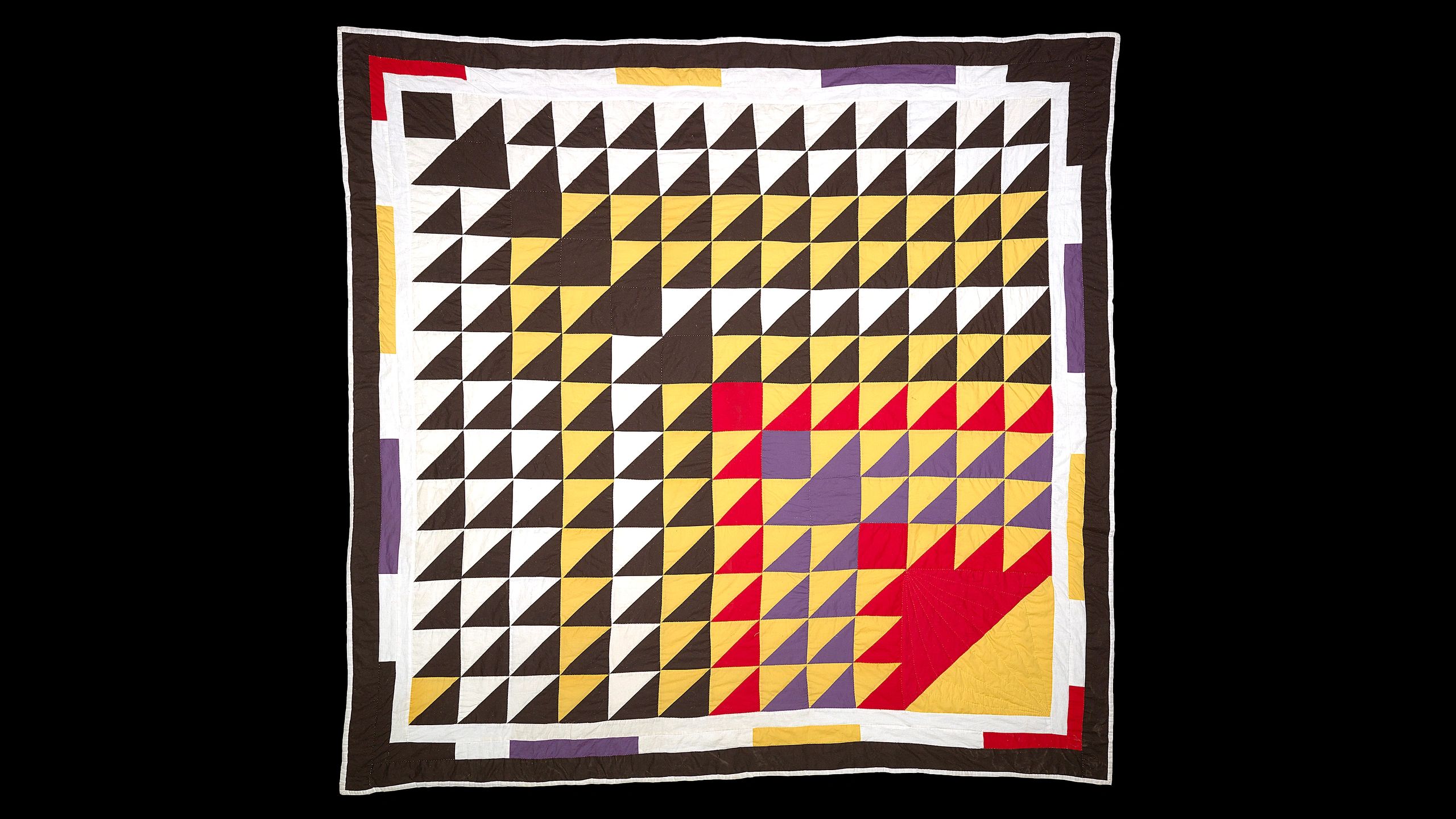 Colorful geometric quilt with triangle patterns.