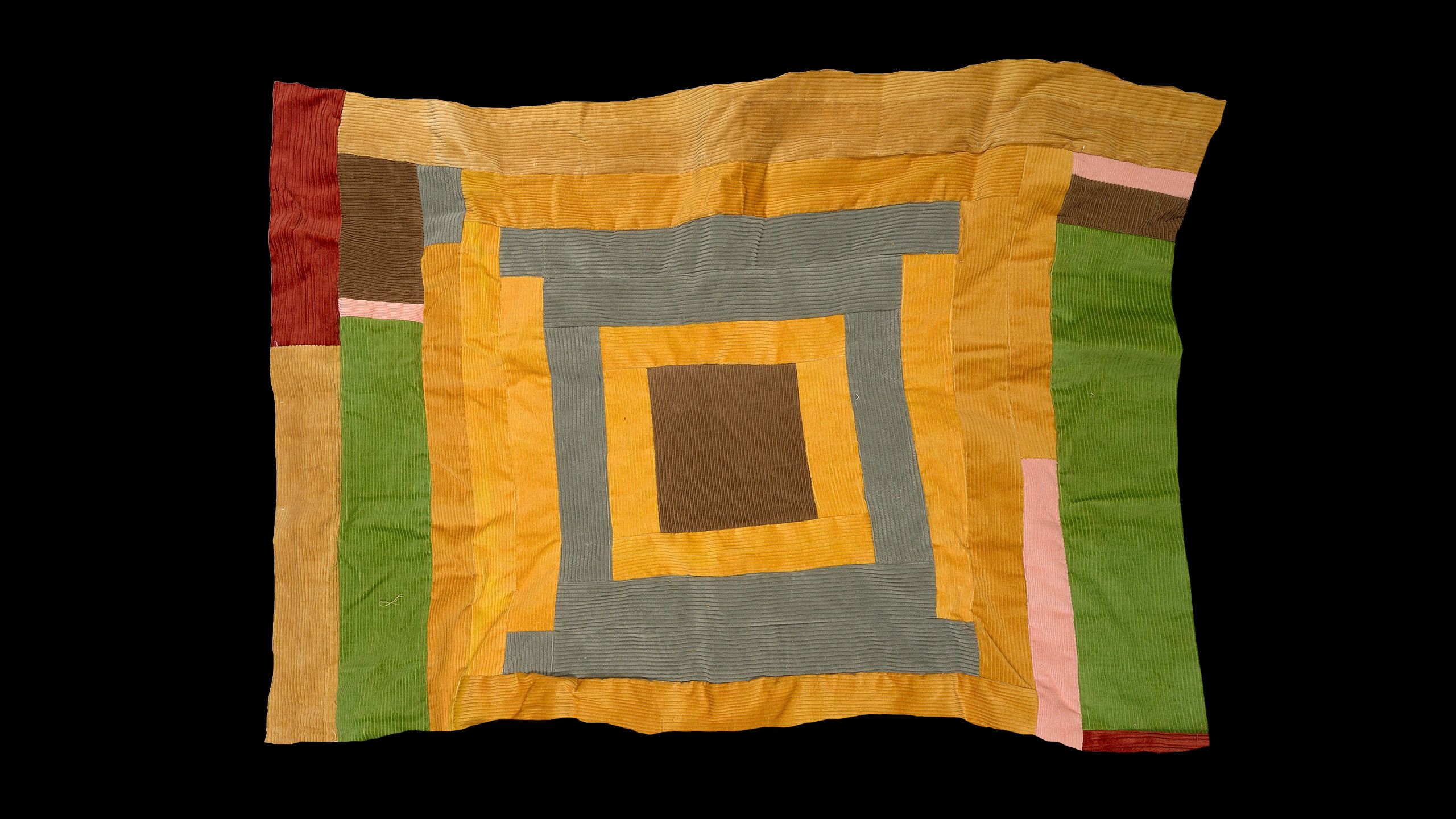 Patchwork quilt with rectangular patterns in earthy tones.