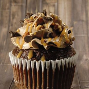 Chocolate cupcake with caramel drizzle and chocolate chips.