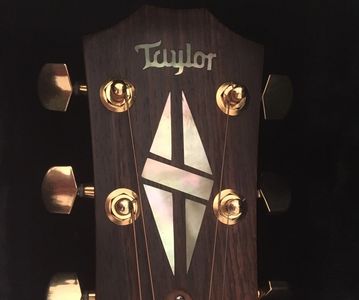 Routed out the plastic Taylor logo, then hand cut a solid piece from gold mother of pearl. 
