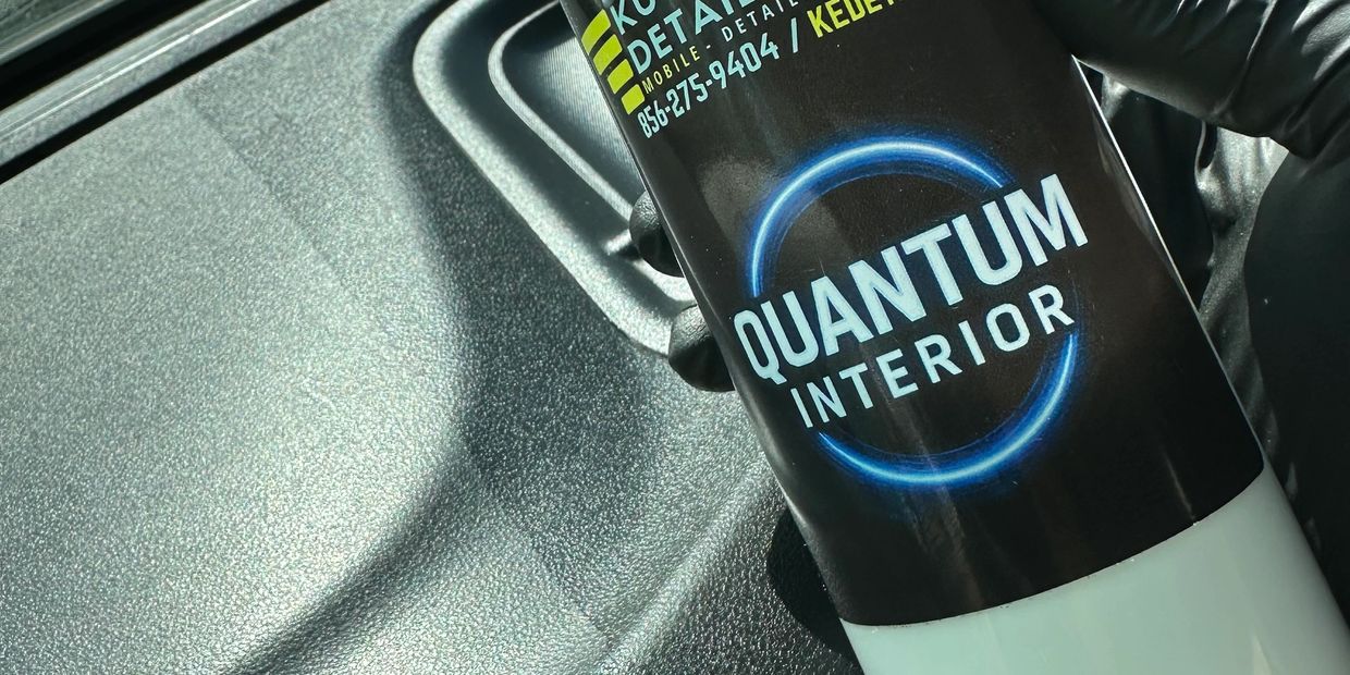 Detailing spray bottle held inside a car.