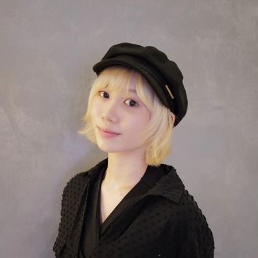 Young woman with blonde hair wearing a black hat and black outfit.