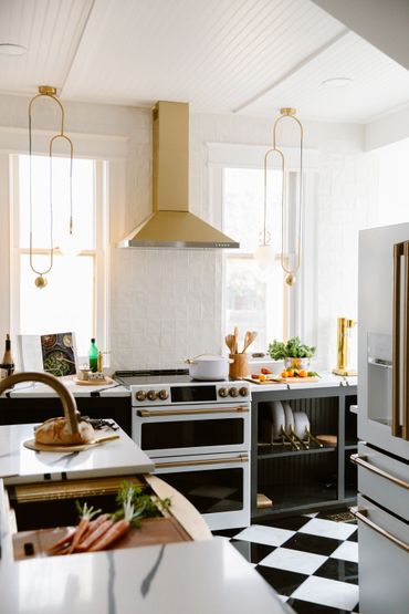 Bright modern kitchen with gold fixtures and black-and-white checkered floor.