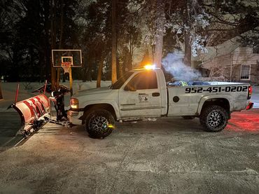 Plow truck in a freshly cleared driveway.