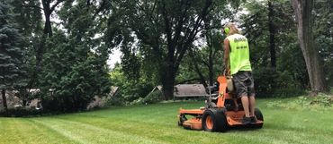 An employee mowing a lawn.