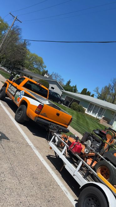 Work truck and trailer in front of a freshly cut lawn