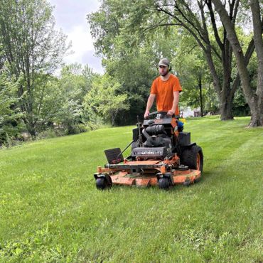 Photo of an employee mowing a customers lawn