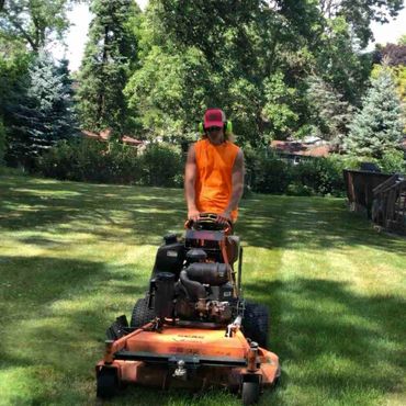 Employee mowing a customers lawn.