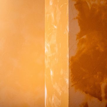 Close-up of textured orange walls with varying shades and patterns.
