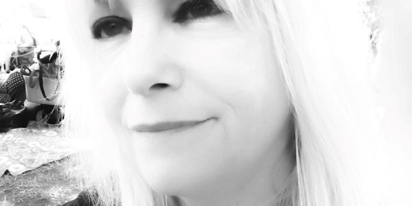 Black and white close-up portrait of a woman with light hair and a gentle smile.