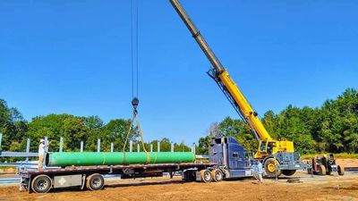 Truck hauling pipes.