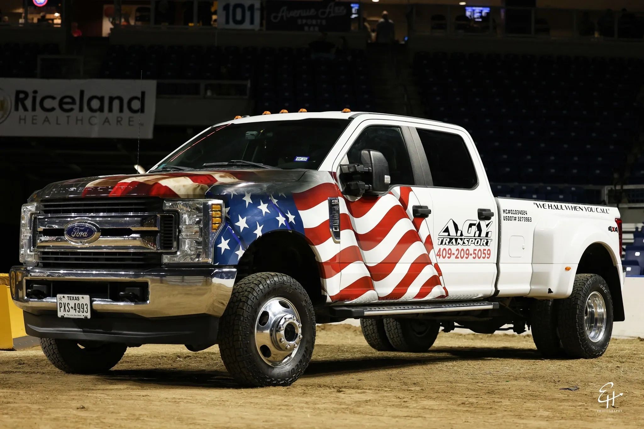 Ford truck with American flag wrap and business branding in indoor arena.